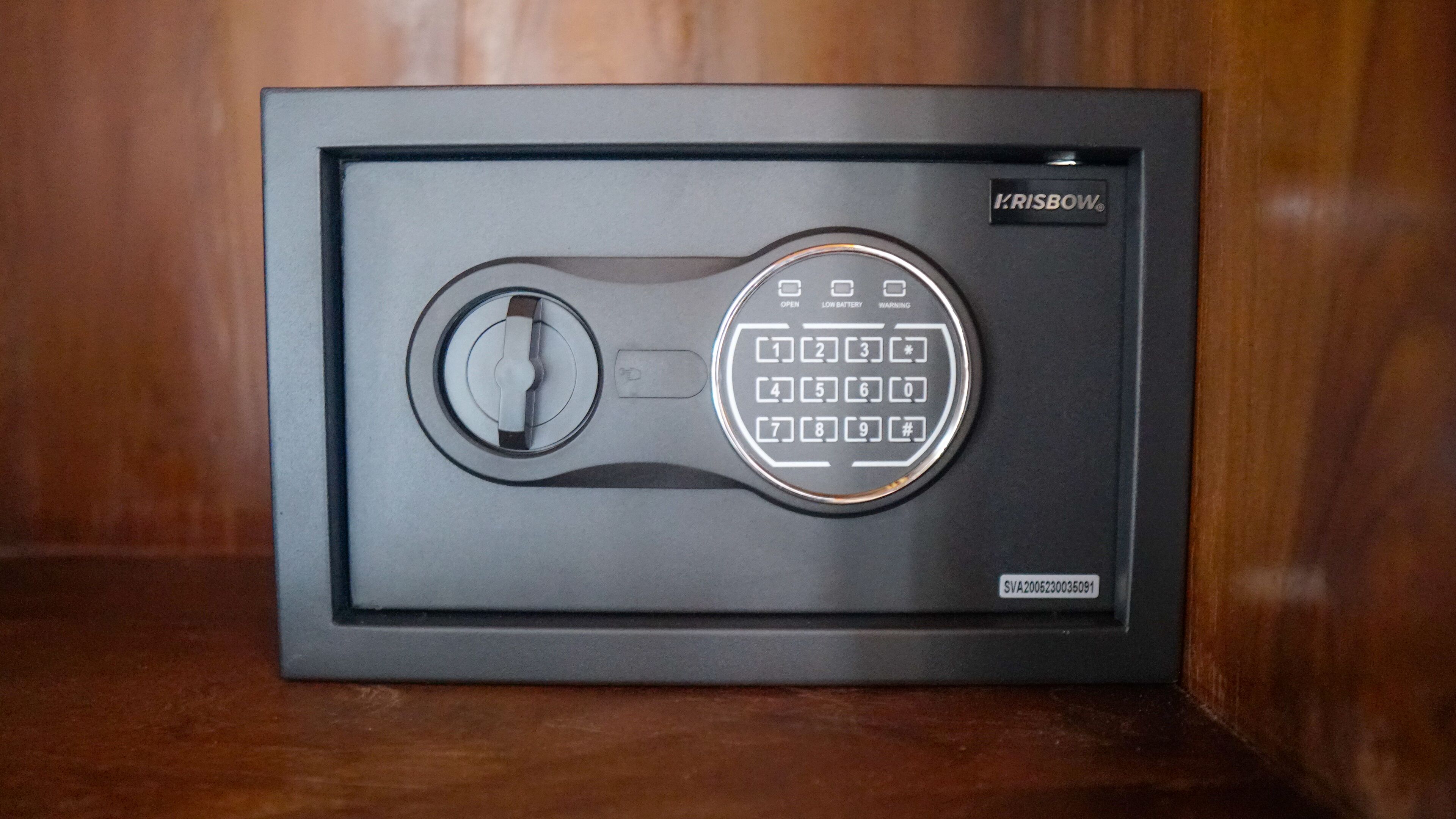 A black safe with a combination dial and a keyhole, labeled "Krisbow."
