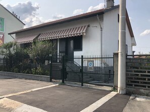 Een gebouw met een hek en een trap naar de ingang, onder een heldere lucht.