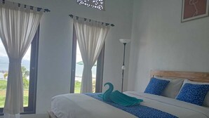 Une chambre à coucher avec un lit, des rideaux, une lampe et une vue sur l’extérieur.