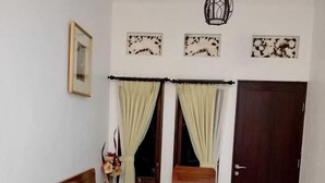 Un salon comprenant un canapé, deux fauteuils, une table basse et une porte.