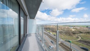 Ein Balkon mit freiem Blick auf eine Autobahn und Gleise.