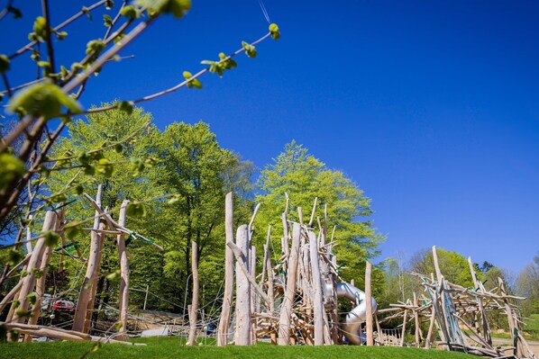 An outdoor sculpture garden with various abstract structures and trees in the background.