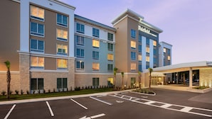 A Marriott hotel with a modern facade, multiple floors, and a parking lot. - NEW - Fairfield Inn & Suites by Marriott Orlando at Millenia (Orlando)