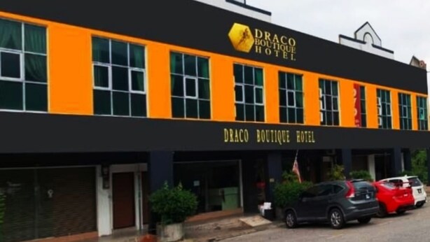 A building with a sign reading "DRACO BOUTIQUE HOTEL".
