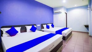 Ein Hotelzimmer mit zwei Betten, jeweils mit blauer Bettwäsche und Kissen, einer weißen Decke und einem gefliesten Boden.