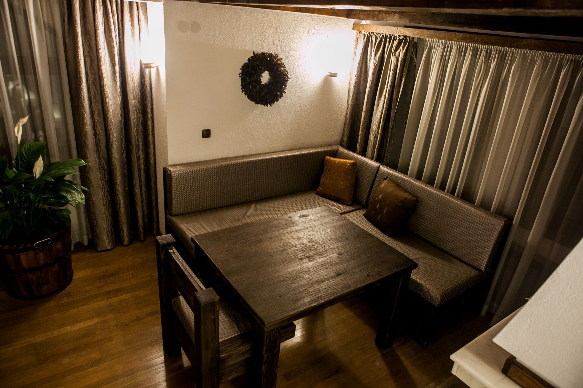 Una habitación acogedora con un banco de madera, una mesita pequeña y una planta en maceta.