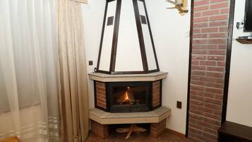 Habitación de esquina con chimenea, un banco de madera y una pared de ladrillo.