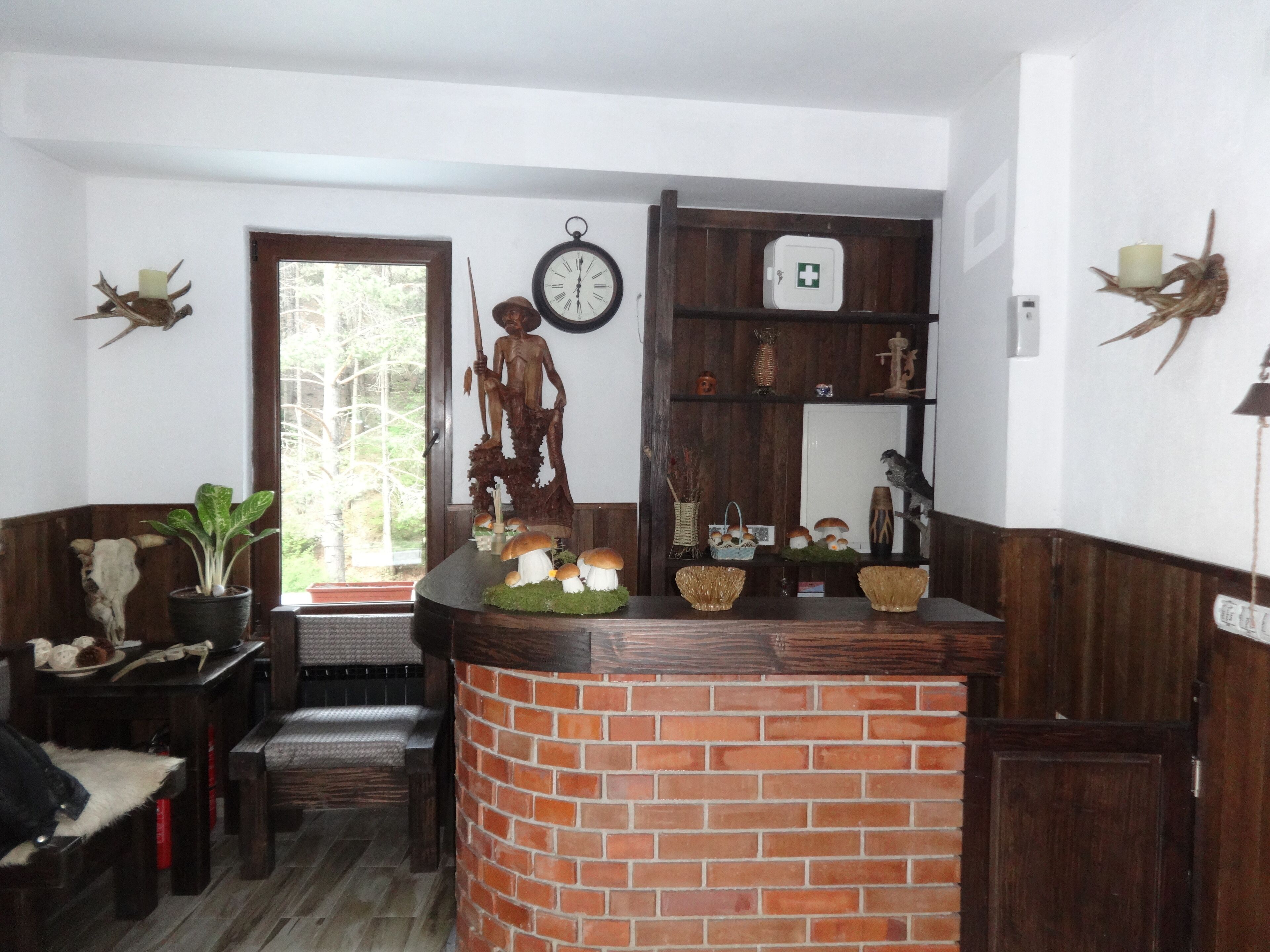 Um quarto acolhedor com lareira de tijolos, prateleiras de madeira, um relógio e decoração rústica.