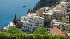 A coastal town with buildings along the cliffside, overlooking the sea.