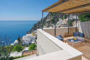 A balcony with a view of the sea and a hillside town. - Villa Romito - Sea view, central location, comfort, garden & terraces (Positano)