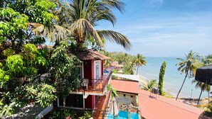Una proprietà fronte mare con piscina, posti a sedere all'aperto e vista sull'oceano.