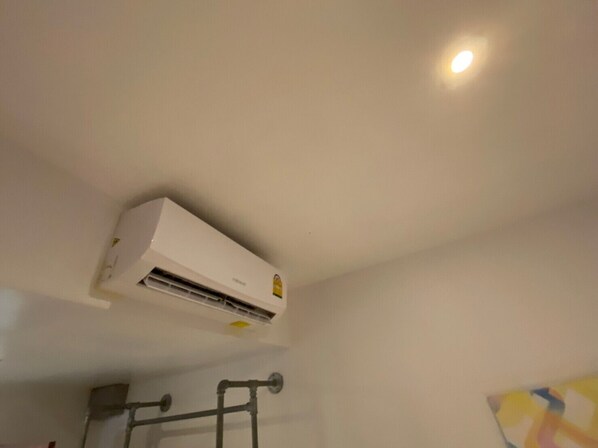 A white air conditioning unit mounted on a wall with a visible control panel.