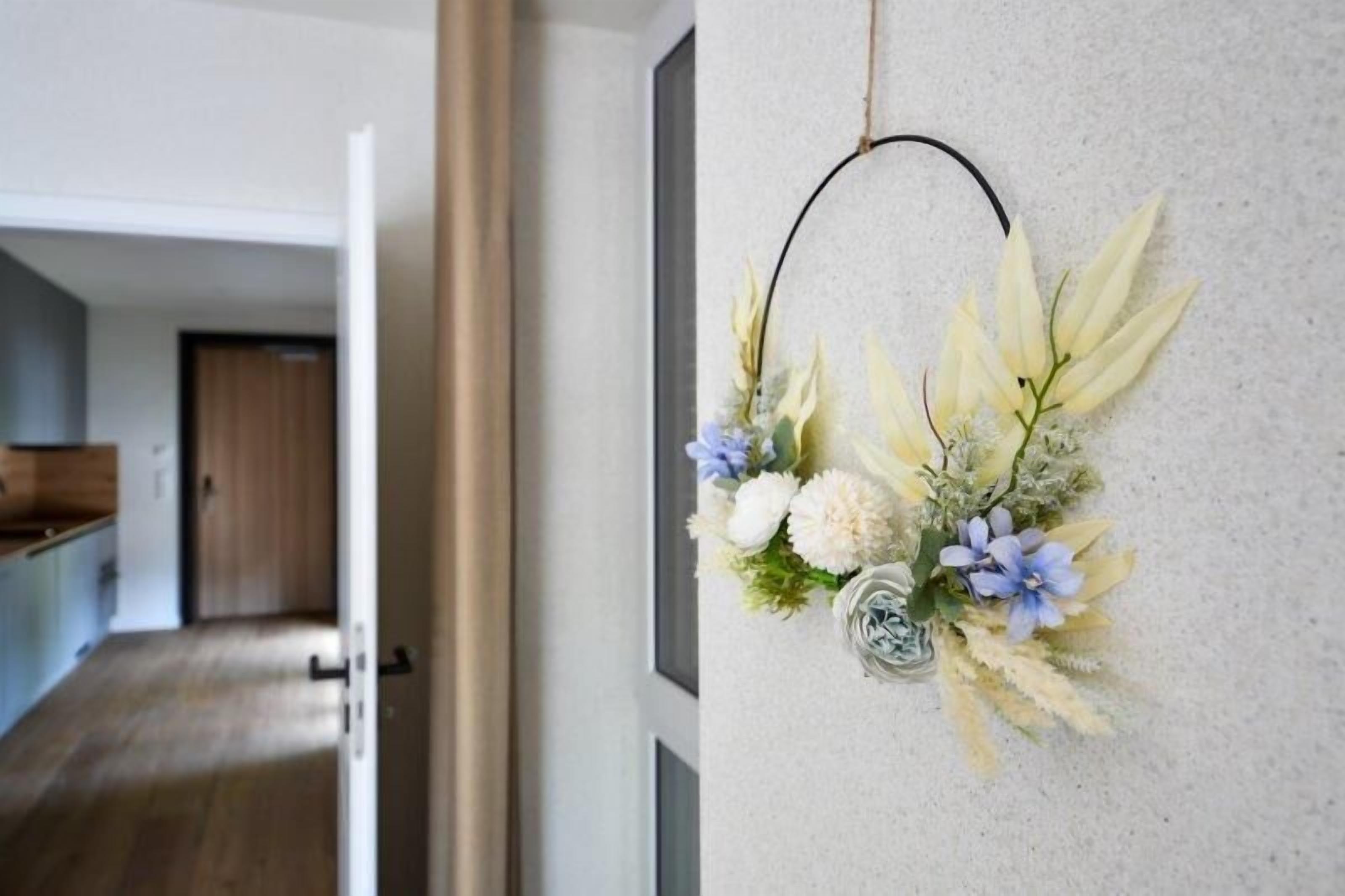 Ein Flur mit einer an der Wand befestigten Blumenkomposition.