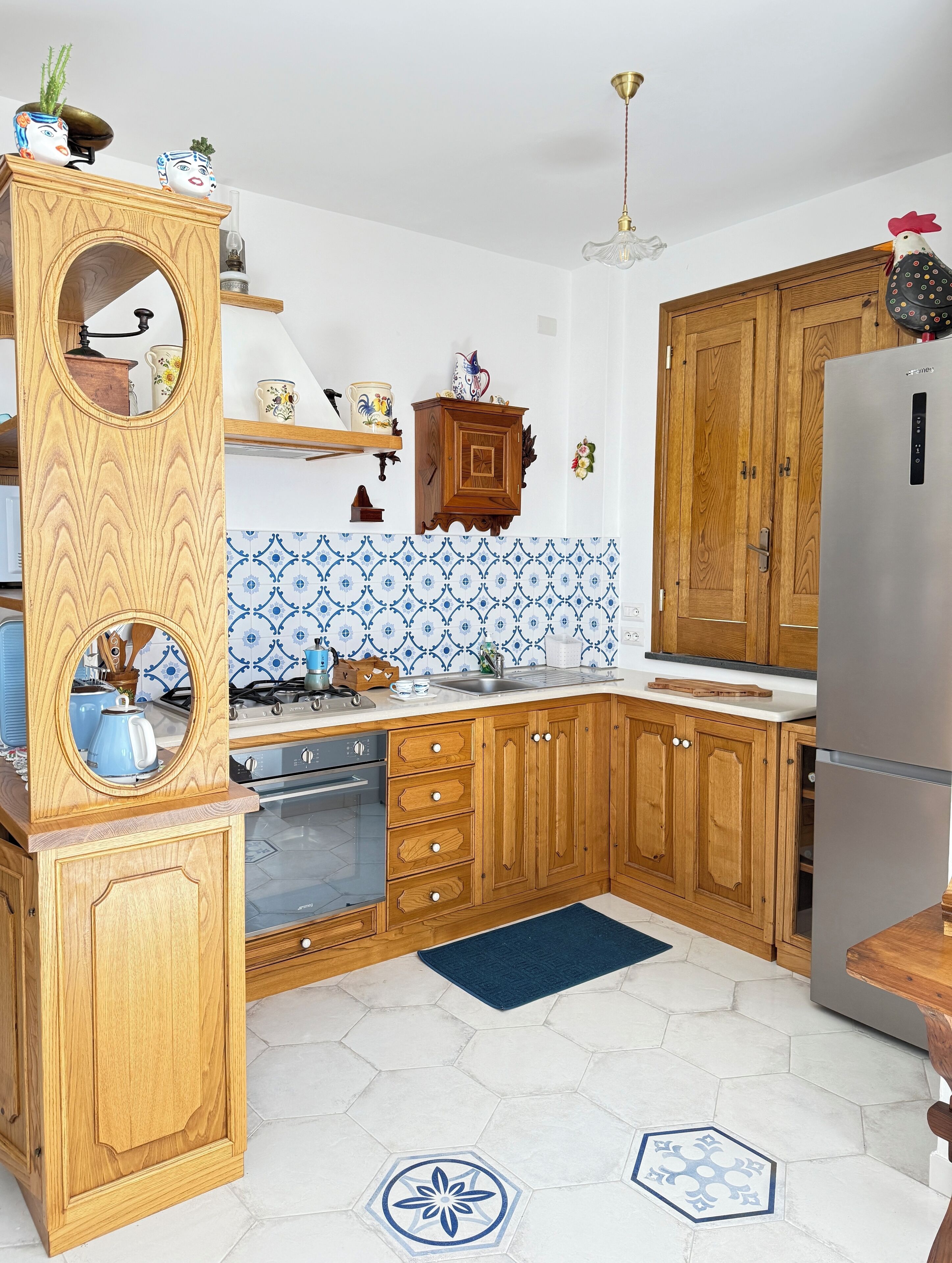Una cocina con armarios de madera, un refrigerador de acero inoxidable y salpicadero de azulejos.