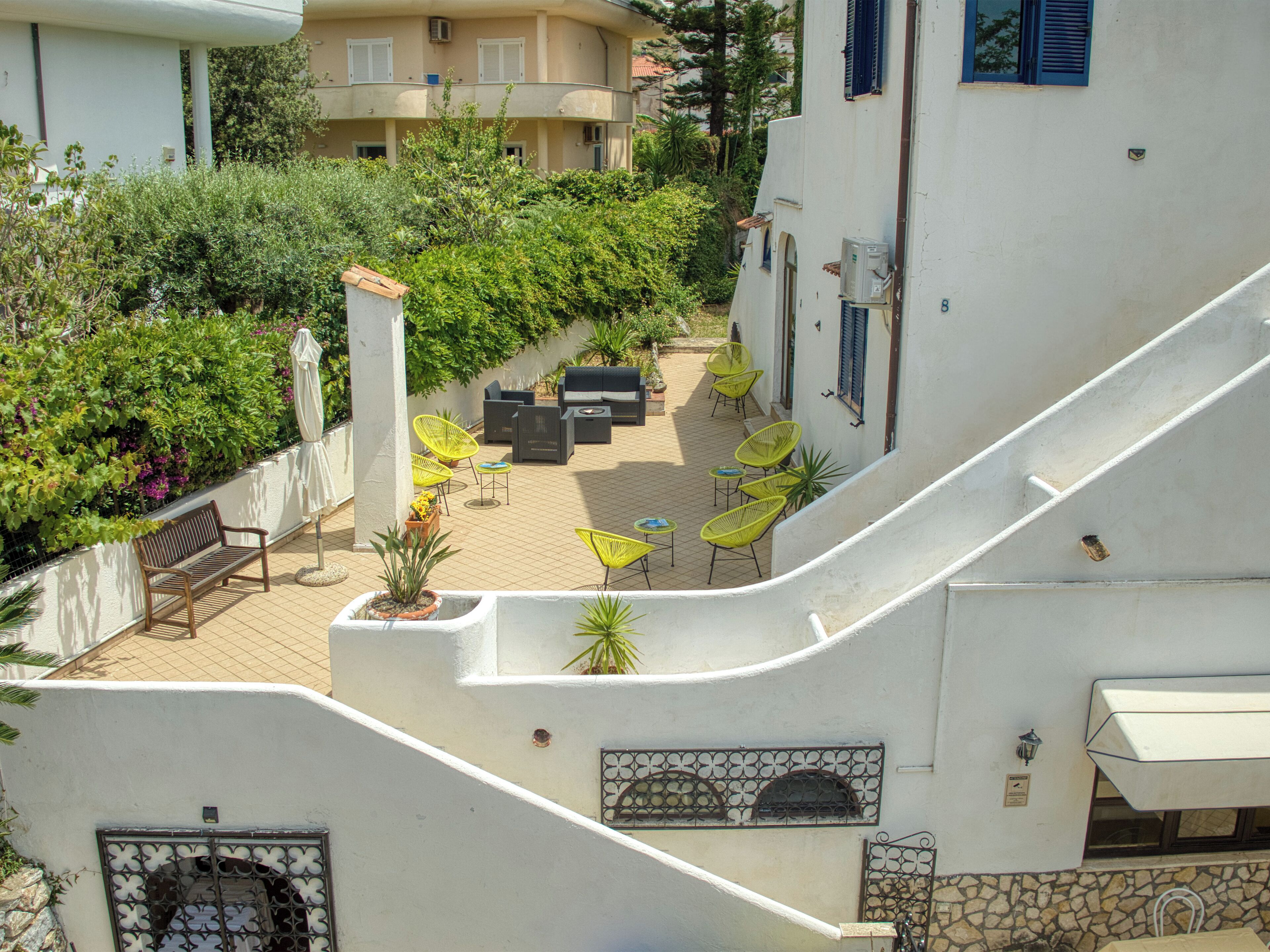A courtyard with outdoor seating, a staircase, and a view of adjacent buildings.