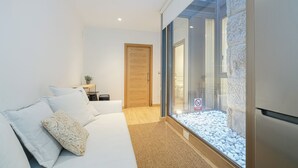 A modern bedroom with a large window, a wooden door, and a bed with white bedding. - Oasis de Elegancia (Vigo)