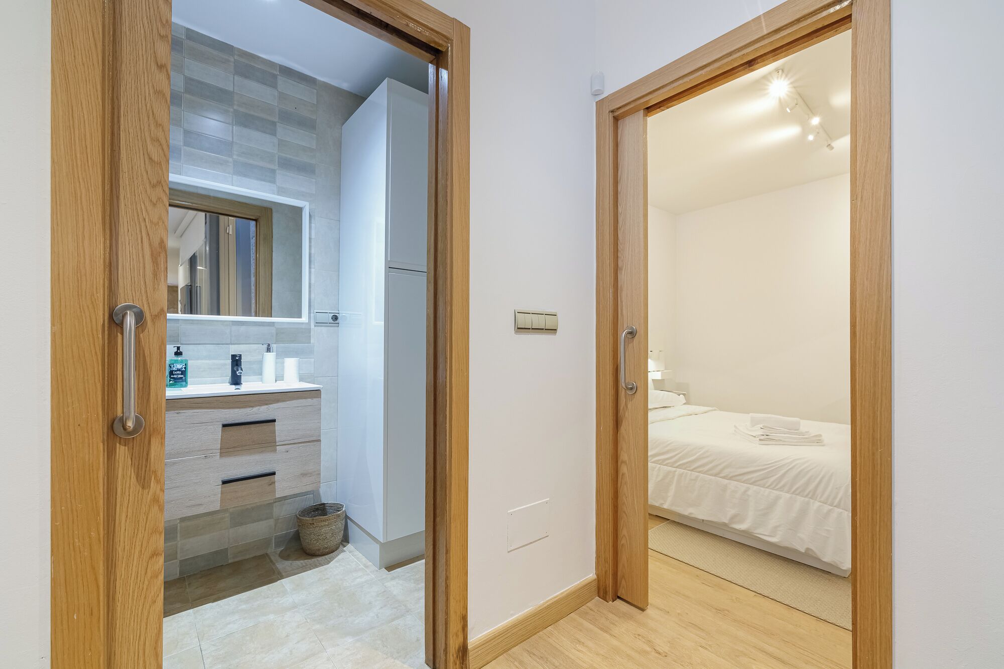 Un dormitorio moderno con una cama, una mesita de noche y un pequeño tocador.