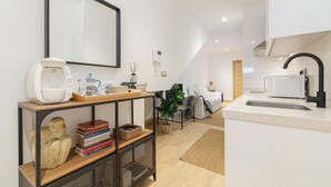 A modern kitchen with a white countertop, a Bosch coffee machine, and a sink with a black faucet. - Oasis de Elegancia (Vigo)