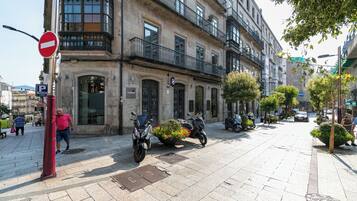 Una calle con un cartel de prohibido el paso, scooters estacionados y un edificio con un letrero que dice "mahlart".