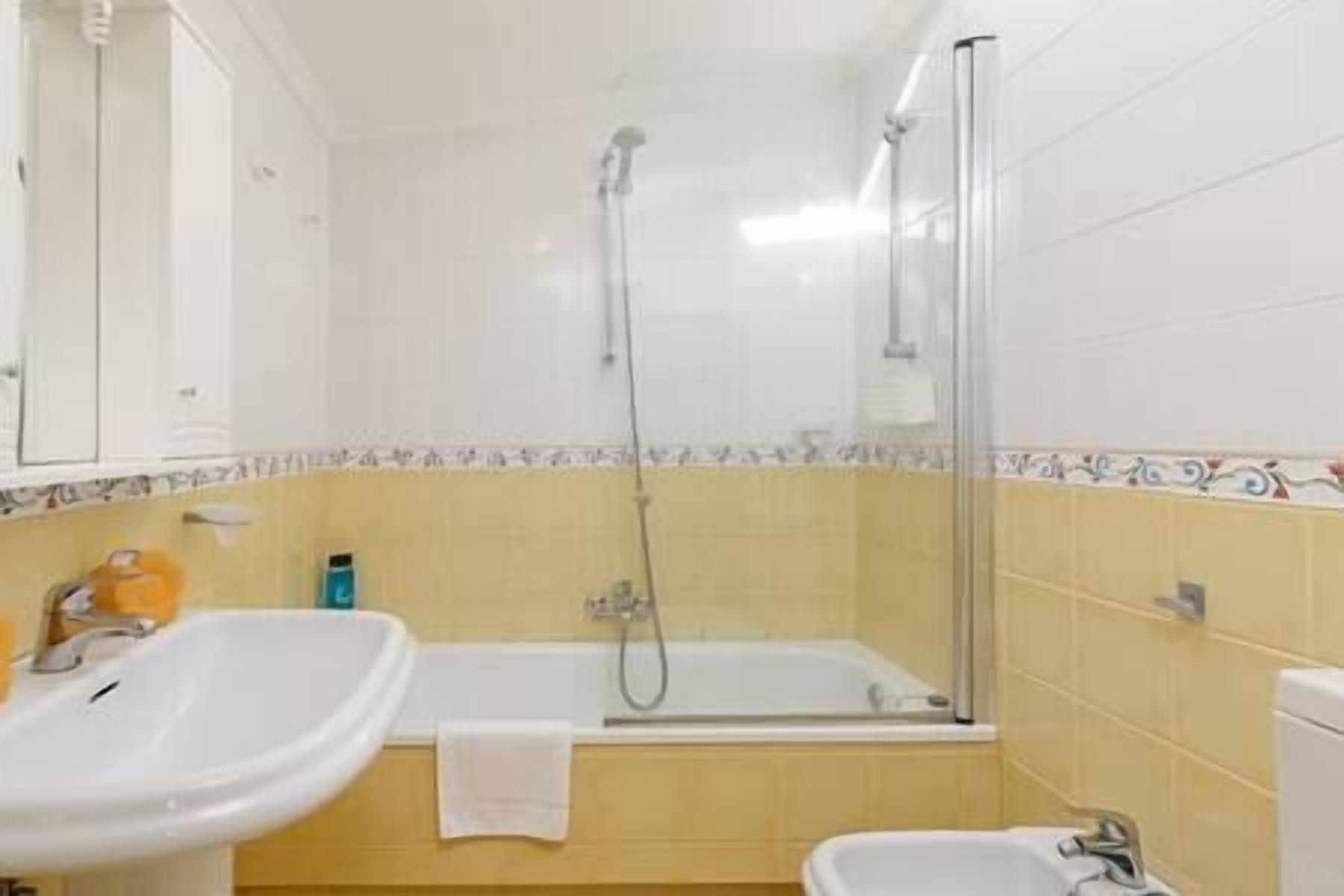 Une salle de bain avec une baignoire, une douche et deux lavabos.