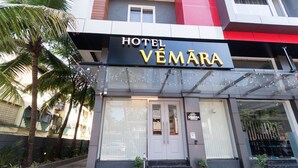 A hotel entrance with a sign reading "HOTEL VEMARA." There are steps leading up to the door, and potted plants are placed at the entrance. - Hotel Vemara (Panaji)