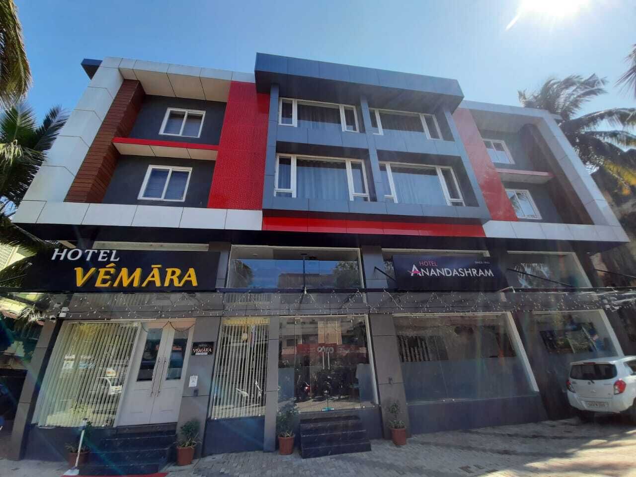 Um hotel chamado Vemara com fachada moderna, apresentando dois andares e um esquema de cores vermelho e azul marcante.