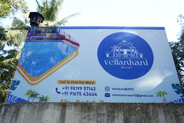 A billboard for Vellankanni Resort with contact information and a tropical design. - Vellankani Resort Gorai (Mumbai)