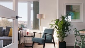 A modern living room with a sofa, a chair, a floor lamp, and a potted plant. - Yewbeck: brand new, garden views (Cumbria)