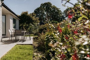 A modern house with a patio, a dining table, and chairs. - Yewbeck: brand new, garden views (Cumbria)