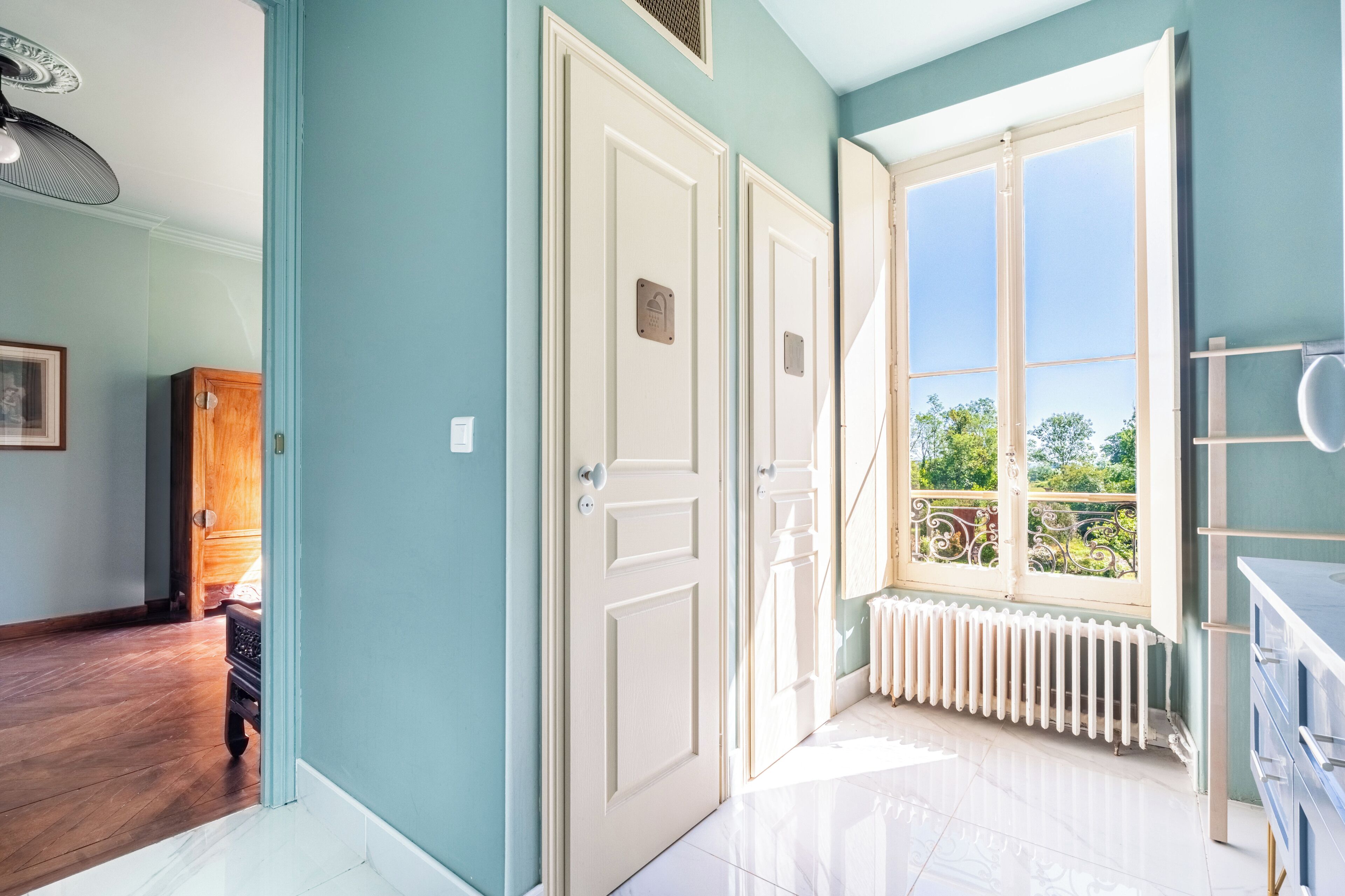 Ein Zimmer mit großem Fenster, Heizkörper und Tür.