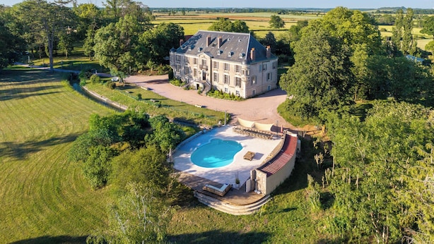 A large, historic house with a swimming pool, surrounded by lush greenery and fields. - Château de Veullerot, with its ponds in the heart of Burgundy (Liernais)