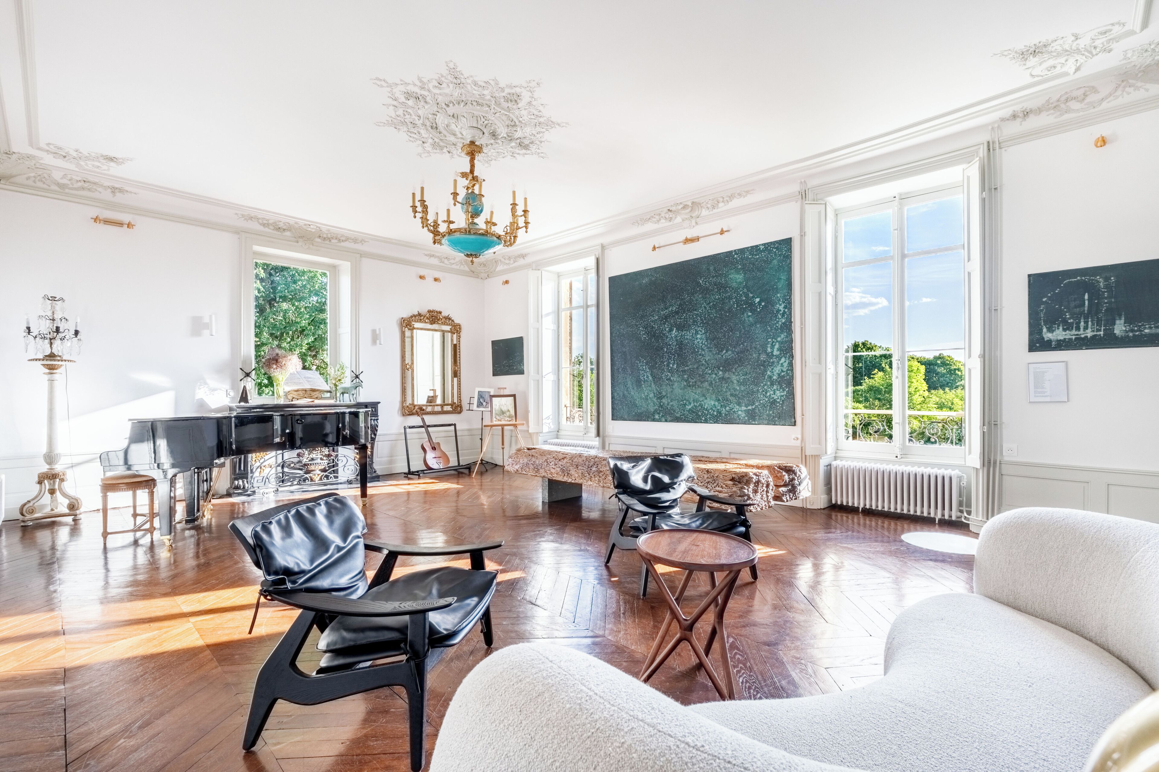 Ein geräumiges Zimmer mit einem Klavier, einem großen Fenster mit Blick und einer Kristallleuchter.