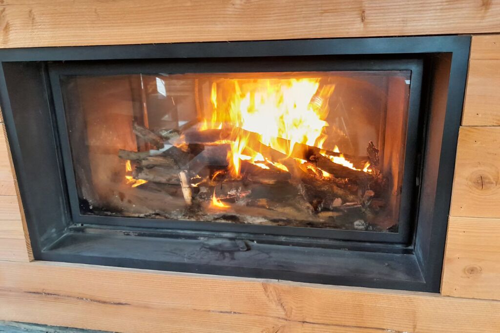 Ein Kamin mit sichtbaren Holzscheiten und Flammen.