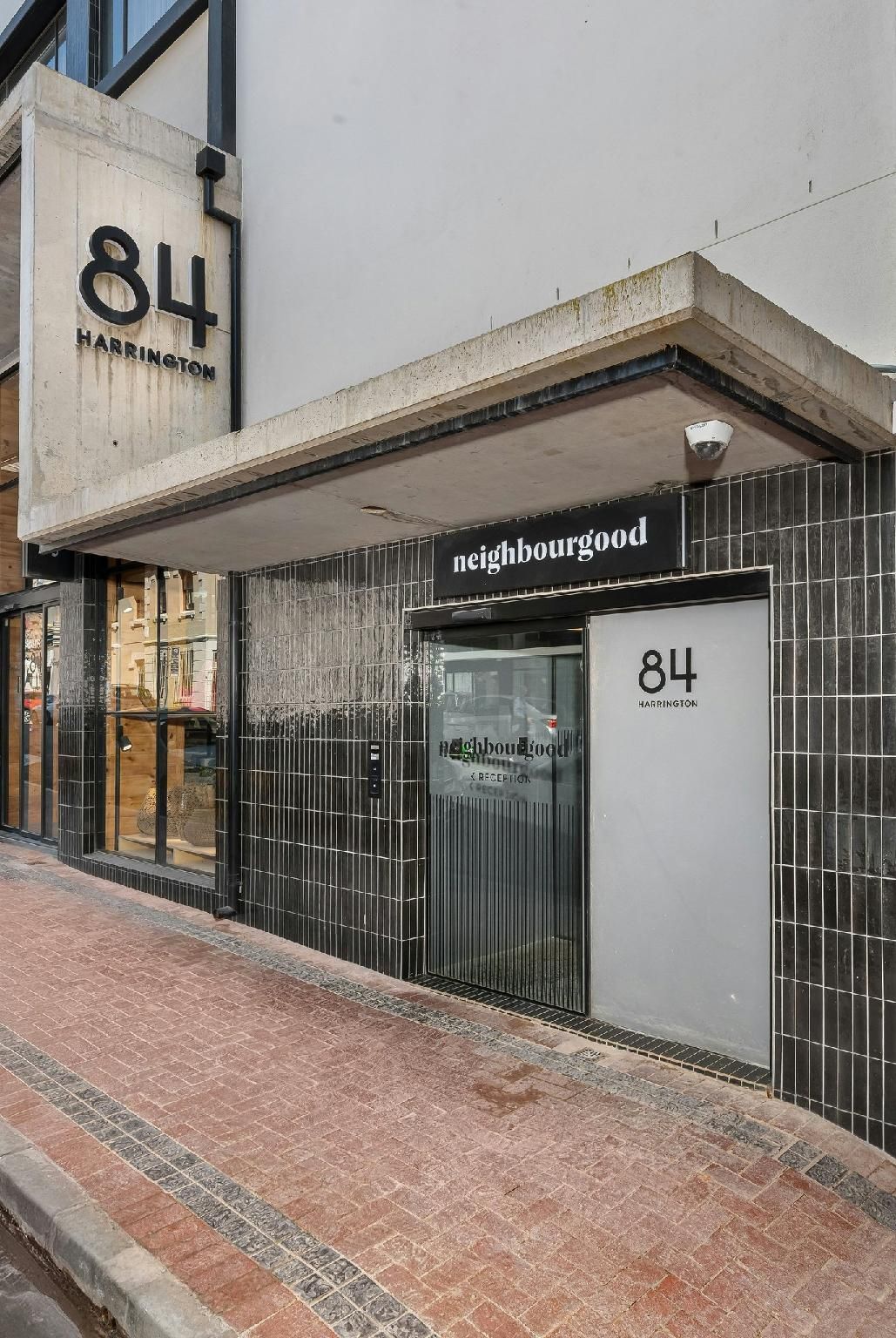 Un edificio con un letrero que dice '84 Harrington' y un escaparate con un cartel que indica 'vecindario'.
