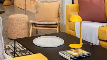 A modern interior with wooden walls, a yellow sofa, a black coffee table, and a red lamp.