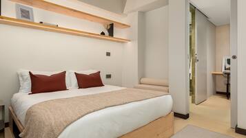 Quarto moderno com uma cama grande, cabeceira de madeira e estantes embutidas.