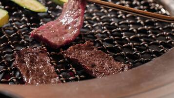 A close-up of a grill with skewered meat and vegetables.