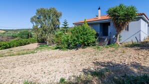 A single-story house with a red-tiled roof, surrounded by a variety of vegetation including trees and shrubs. - Crete Getaway 3Bd Apt w Garden and View (Malevizi)