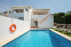 Ein Swimmingpool mit Rettungsboje, einer Treppe und einer Tür zu einer oberen Etage.