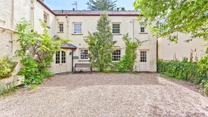 A building with a gravel driveway, a bench, and a sign that reads "The Bridge House". - Sleeps 12 guests in 6 bedrooms with 2 hot tubs (Coniston)