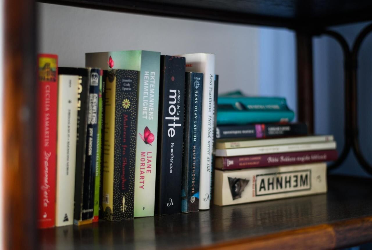 A bookshelf with various books, some with visible titles and authors.