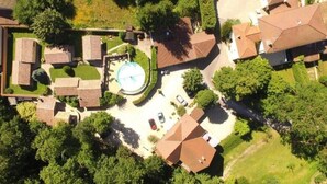 Vista aérea de una zona residencial con casas, piscina y estacionamiento.