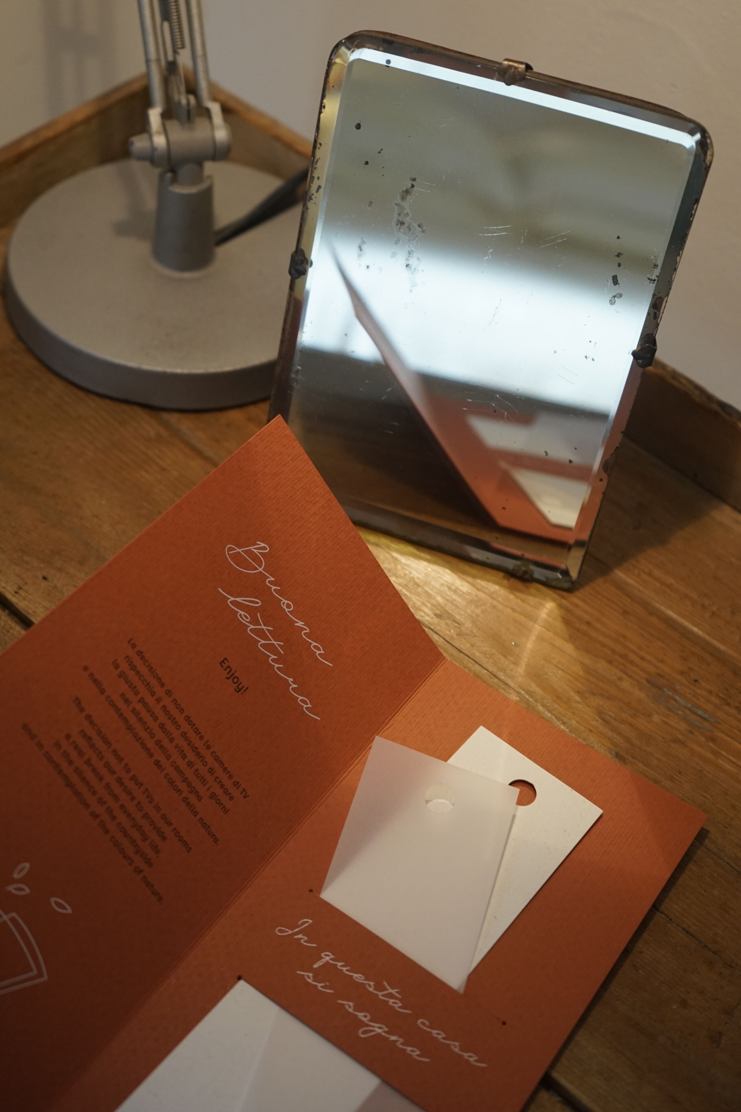A brochure with text and a mirror reflecting part of the room.
