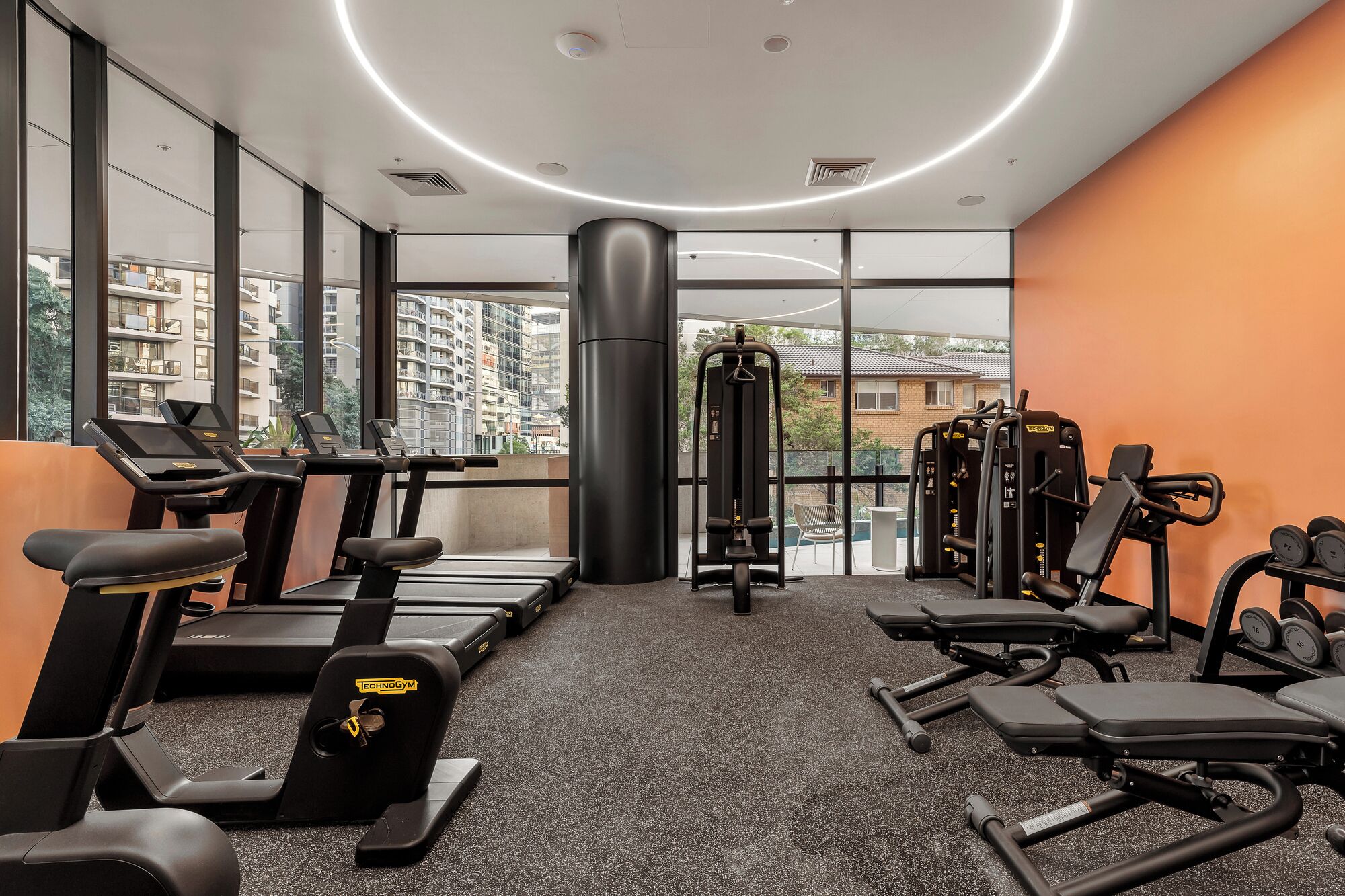 A gym with treadmills, weight machines, and a squat rack.
