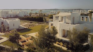 A modern resort with white buildings, a central courtyard, and a view of the sea. - Anapnoe Resort by ParosKite (Paros)