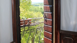 An open door leading to a balcony with a view of greenery and a distant landscape. - Villa Flangini (Asolo)