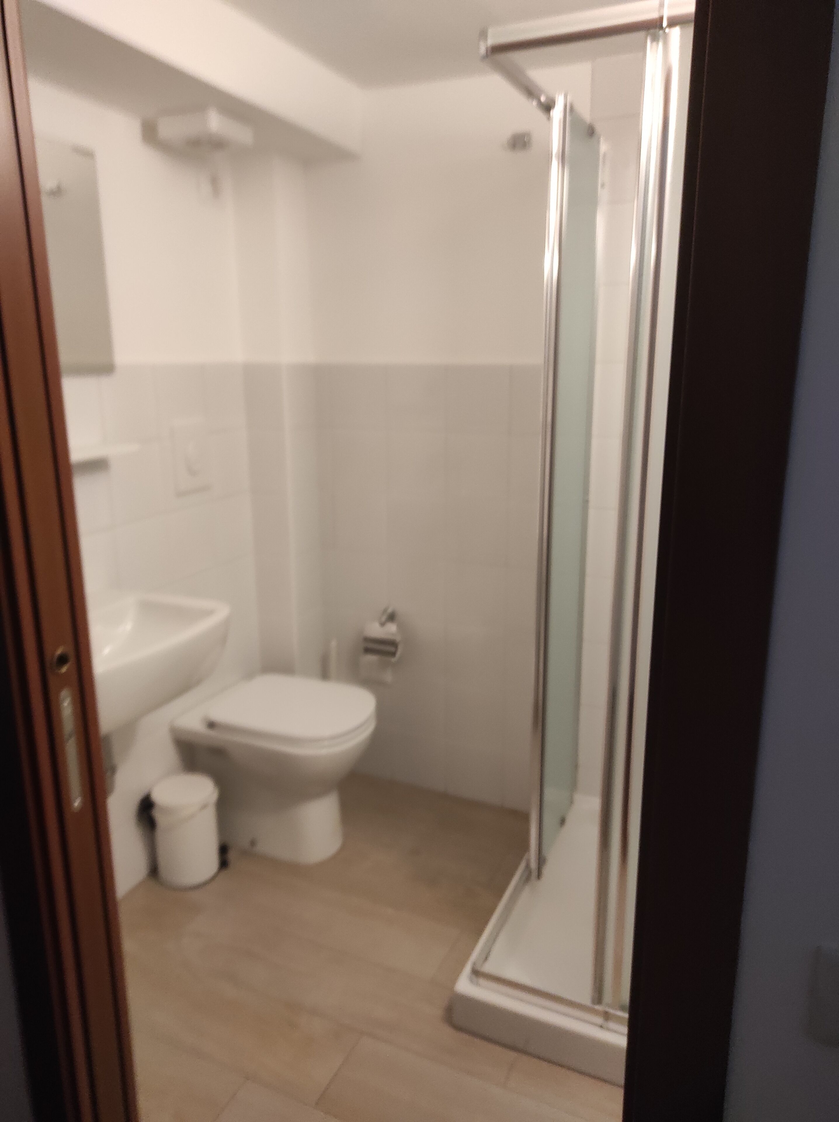 Ein Badezimmer mit Toilette, Waschbecken und einer Duschkabine aus Glas.