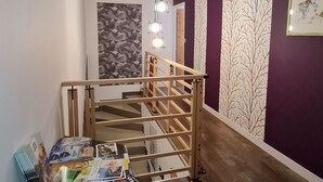 Un escalier avec une rampe en bois menant à l’étage supérieur.