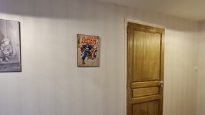 Un couloir avec une porte en bois et une affiche accrochée au mur.