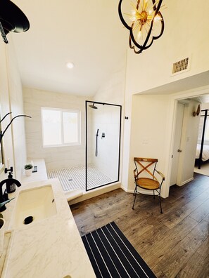 A modern bathroom with a shower, a sink, and a chair. - Rustic Chic Farmhouse retreat with Pool & Spa in North Scottsdale (Cave Creek)